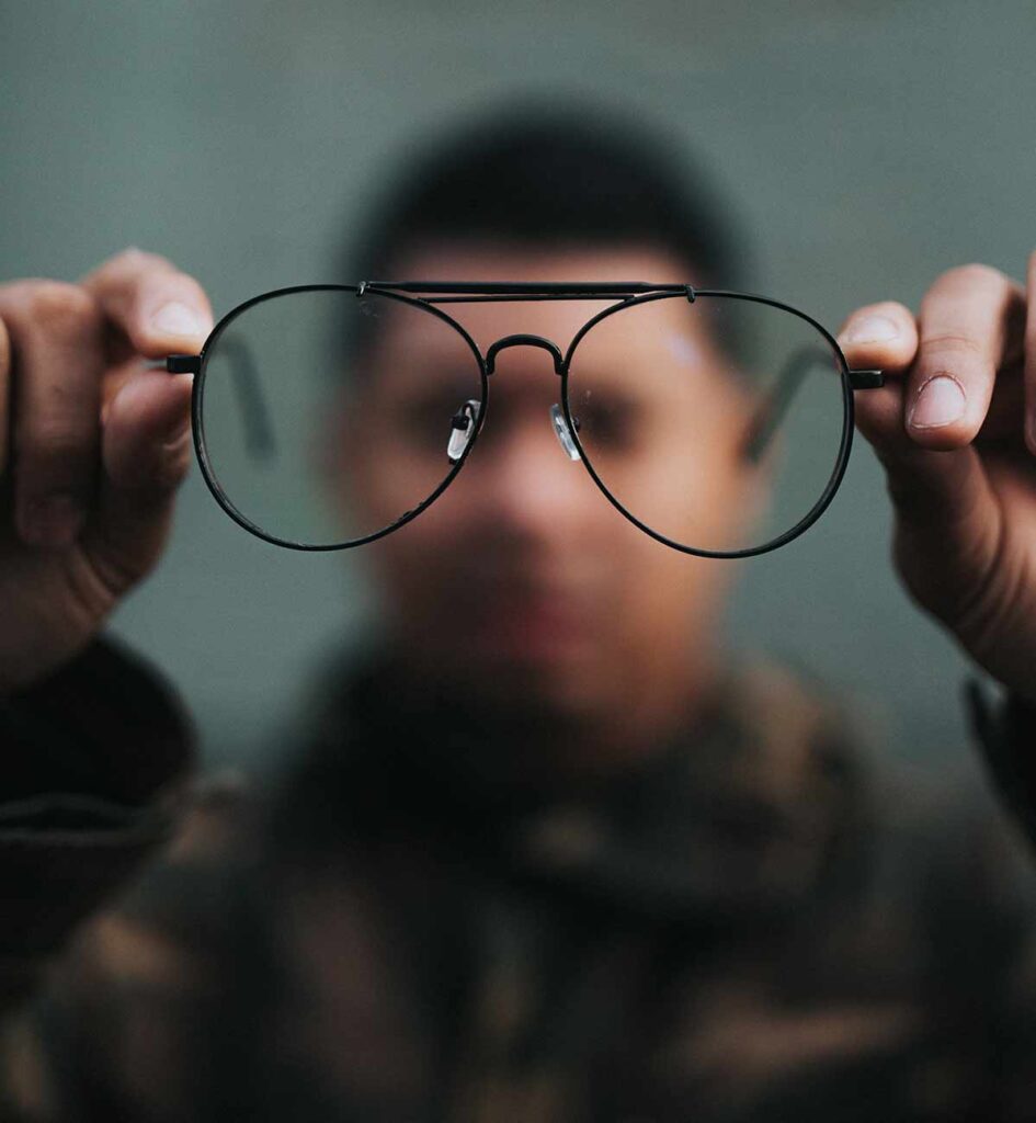 A man holds glasses and the image is blurred